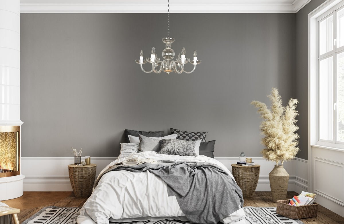 Luminaire suspendu au-dessus d'un lit dans une chambre grise et blanche