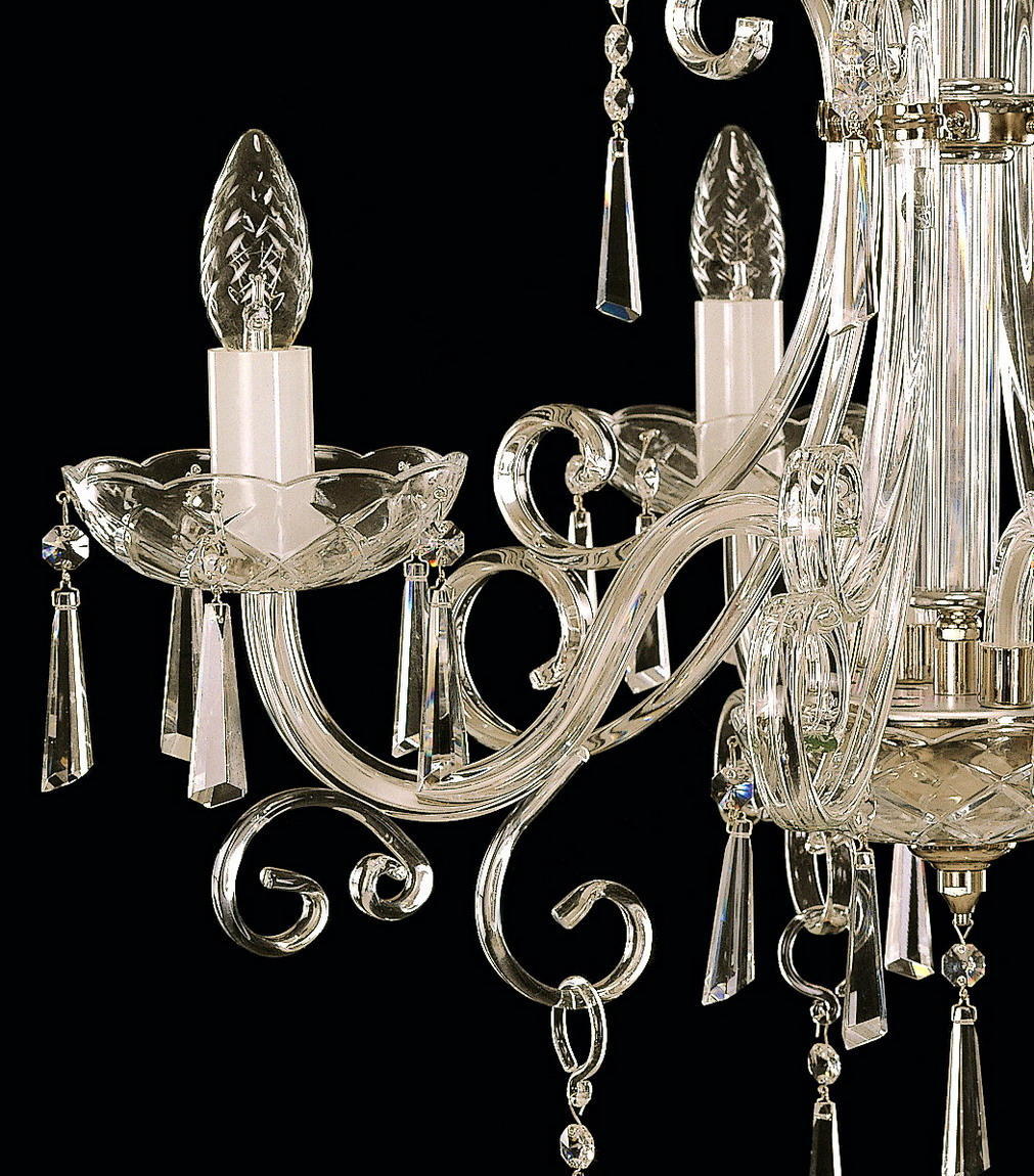 Gros plan sur les douilles, ampoules torsadées et pendentifs transparents du luminaire.
