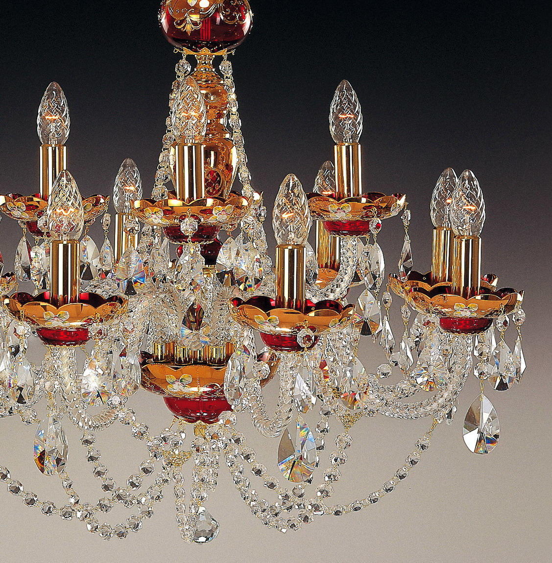Détail des bras dorés, bobèches rouges et pendeloques en cristal taillé