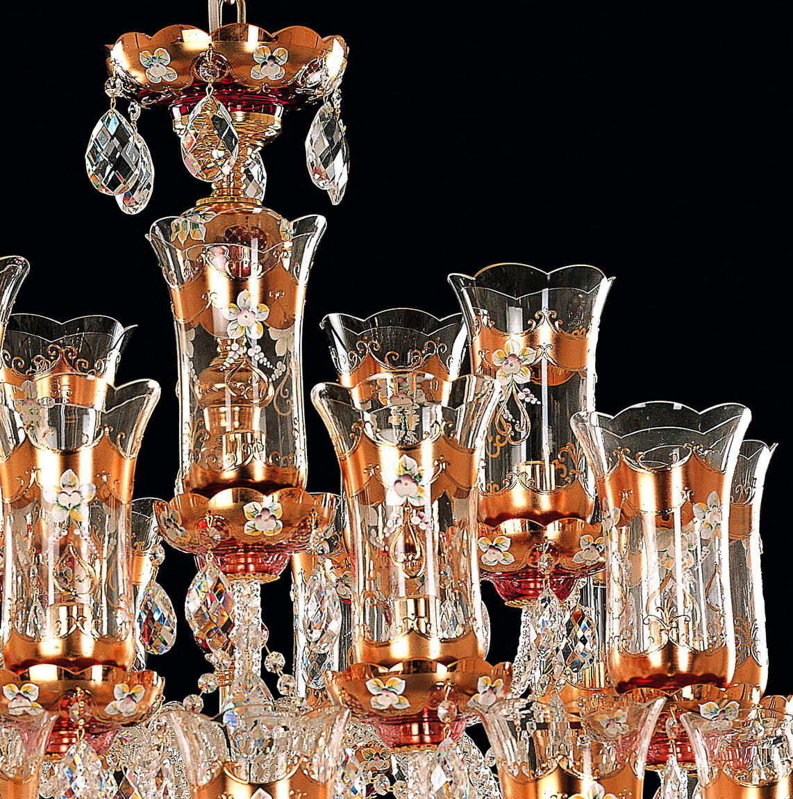 Gros plan sur les coupelles dorées et cylindres de verre décorés de fleurs émaillées