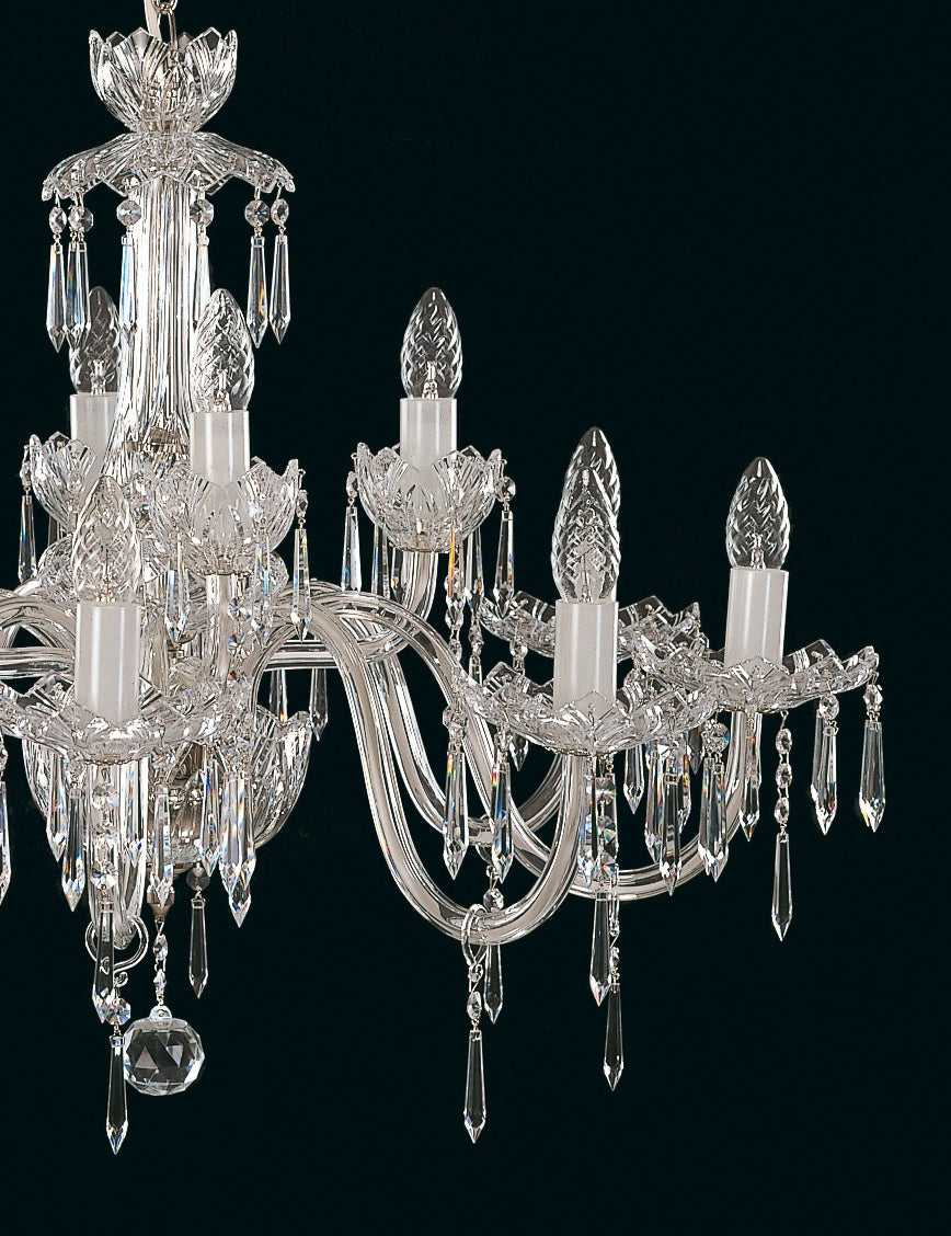 Gros plan sur les bras du lustre et ses longues gouttes de cristal.