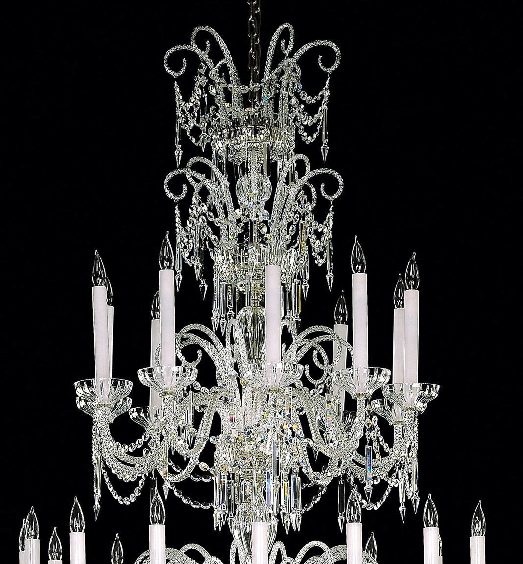 Détail du haut du lustre : cristaux, bras courbes et douilles en forme de coupelle.