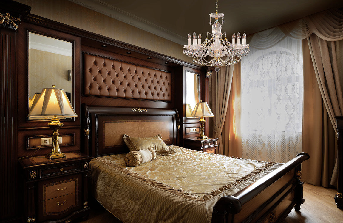 Lustre suspendu au-dessus d'un lit capitonné dans une chambre classique