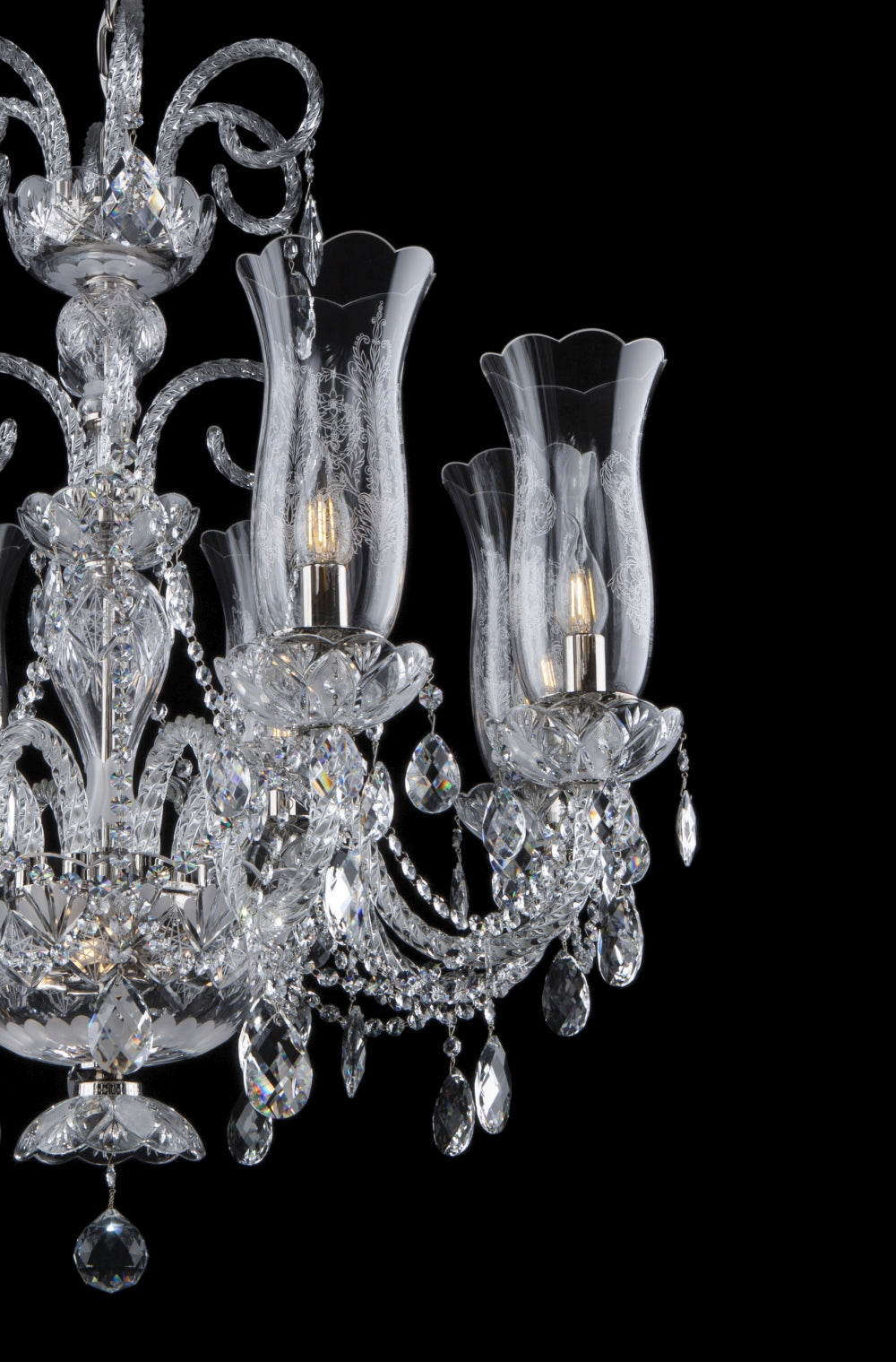 Gros plan sur les bras, les coupelles et les pendentifs de cristal taillé.