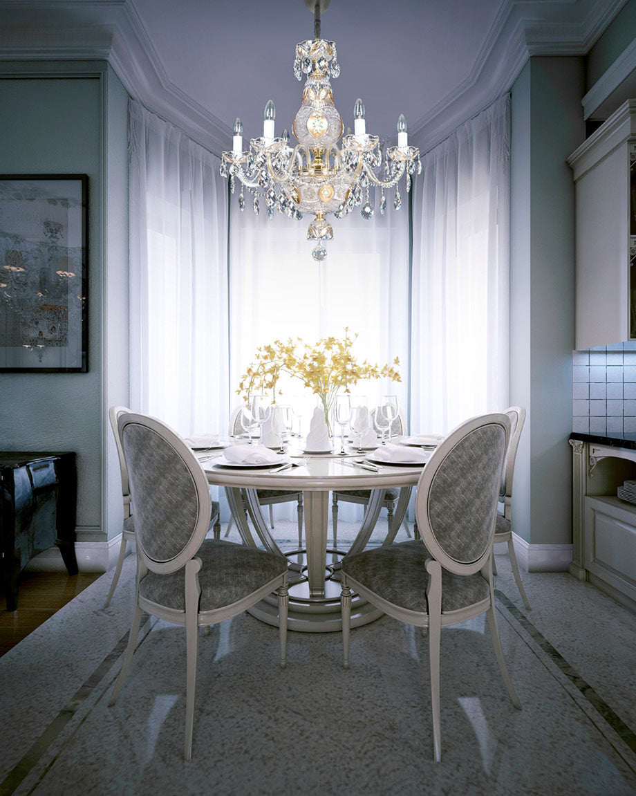 Lustre en cristal installé au-dessus d'une table dressée dans une salle à manger claire.