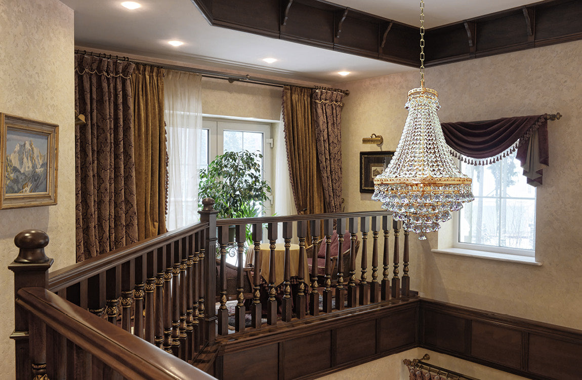 Lustre suspendu près d'un escalier aux boiseries sombres, ambiance classique