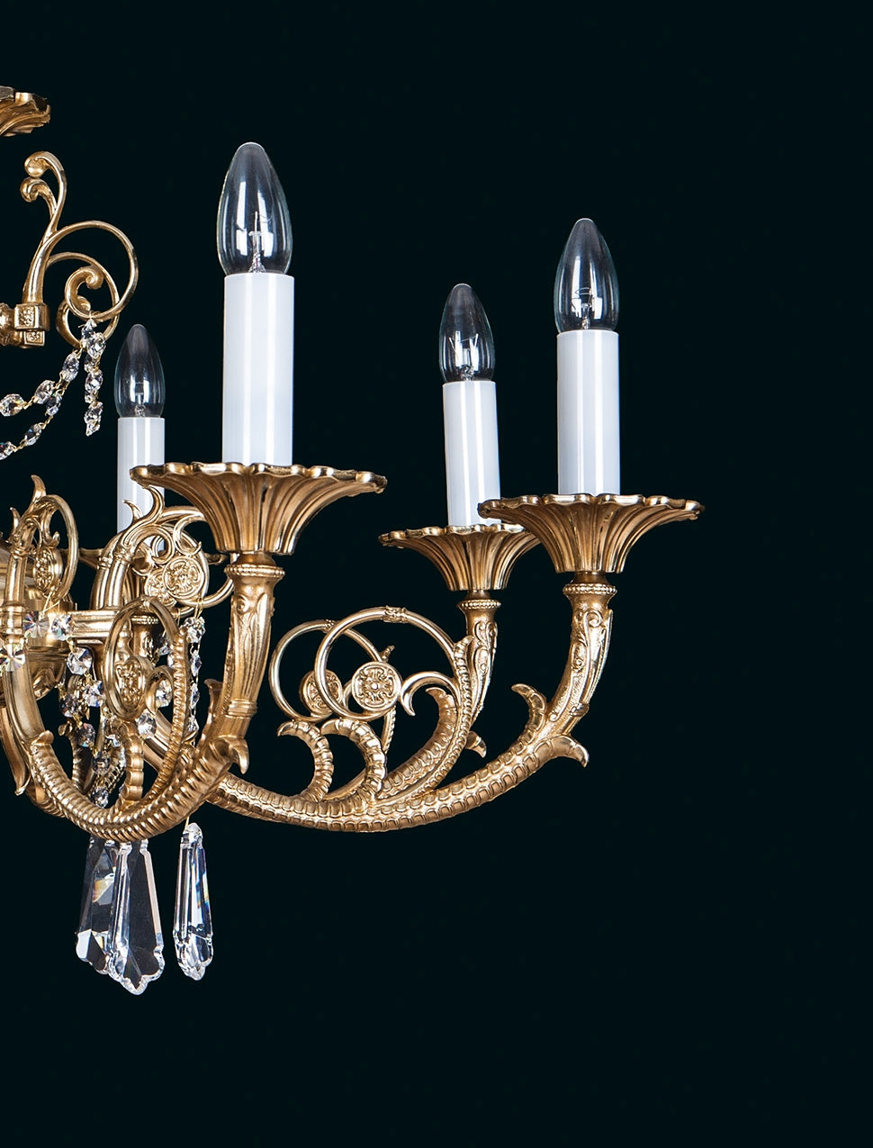 Détail de deux bras moulurés avec coupelles dorées festonnées et bougies blanches.