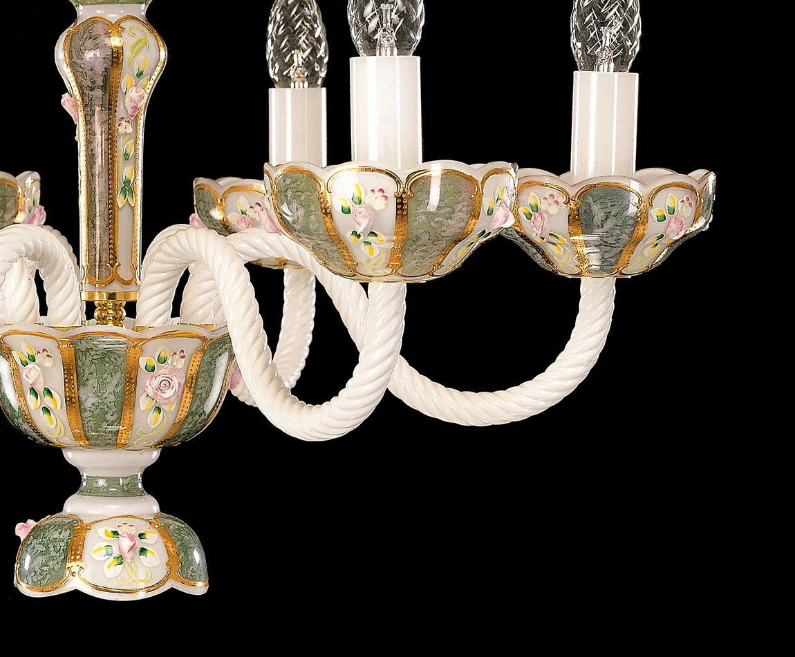 Détail rapproché des bras torsadés et coupelles fleuries dorées du lustre