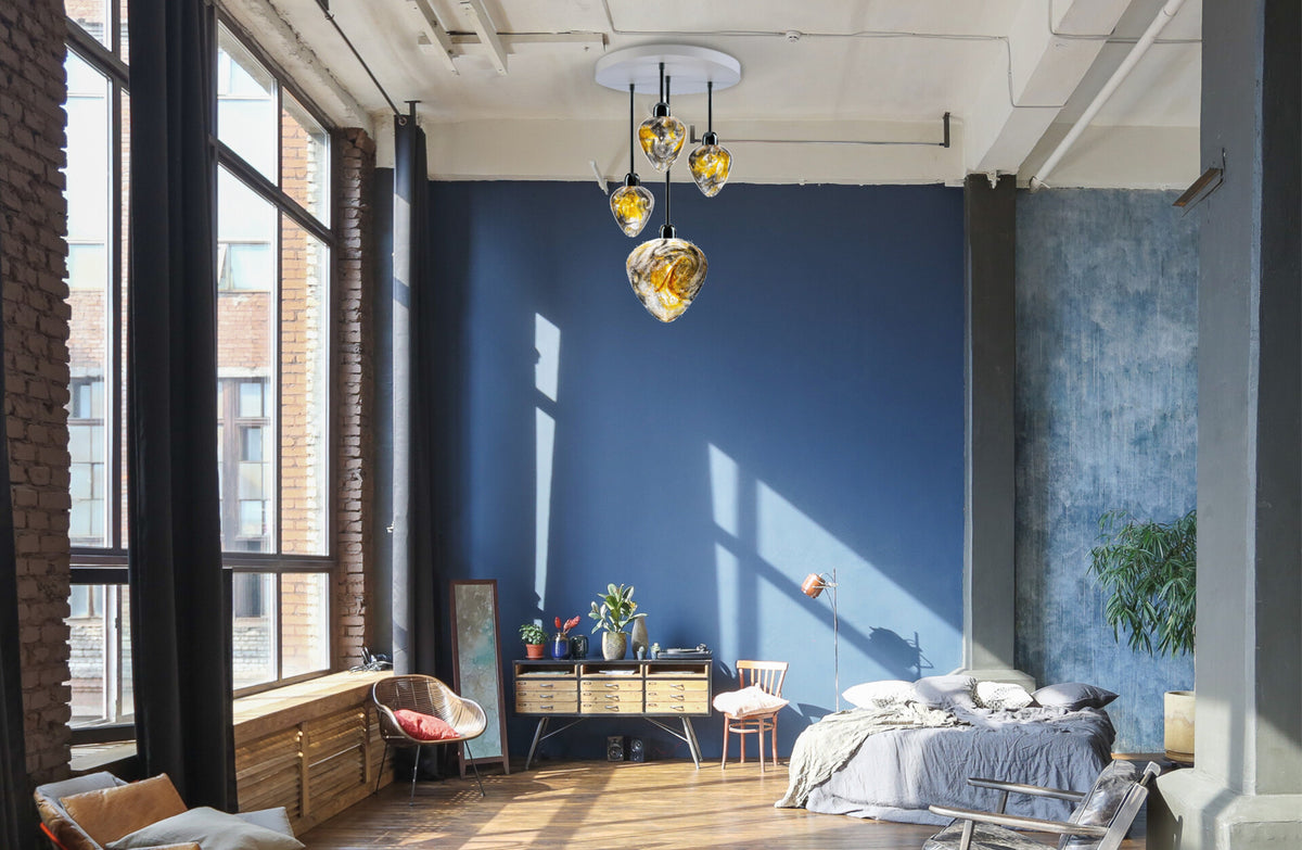 Mise en ambiance dans un loft à mur bleu, suspension allumée au plafond