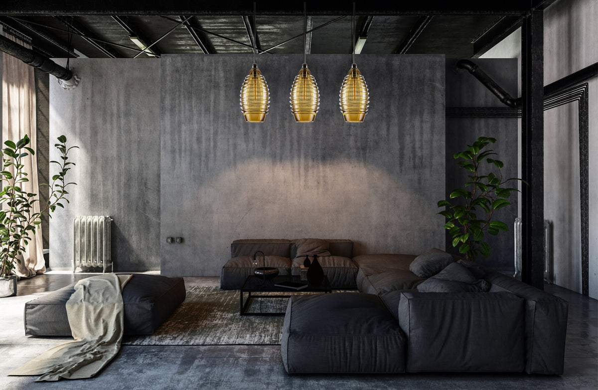 Trois luminaires dorés alignés au-dessus d'un salon gris au mur de béton