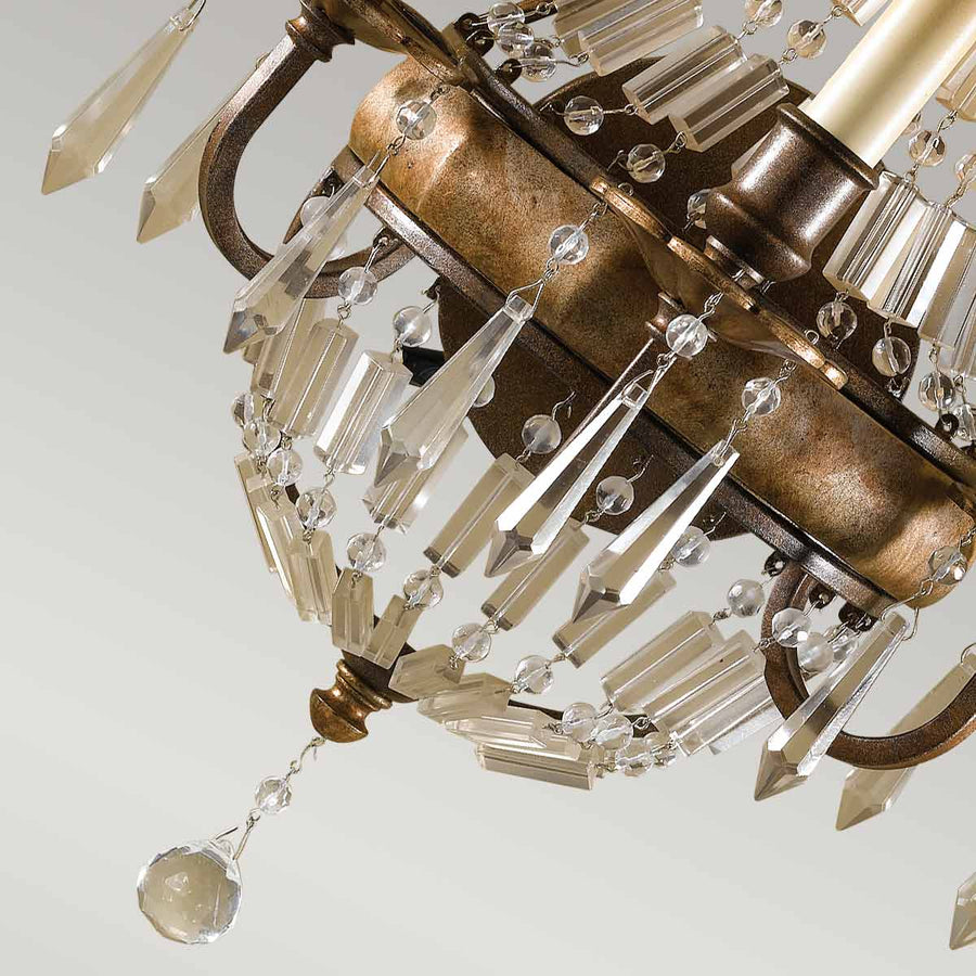 Détail du bas du luminaire : finition bronze vieilli et grappes de cristaux taillés.