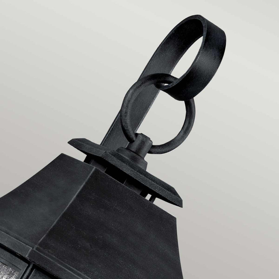 Détail du sommet : anneau décoratif noir et fixation, gros plan sur le crochet.