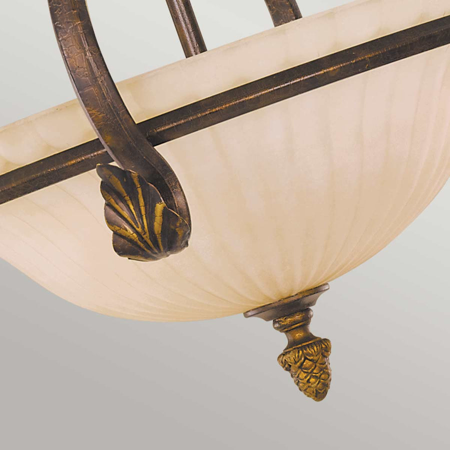 Détail de la finition, motif feuille ciselée dorée et pendentif en pomme de pin