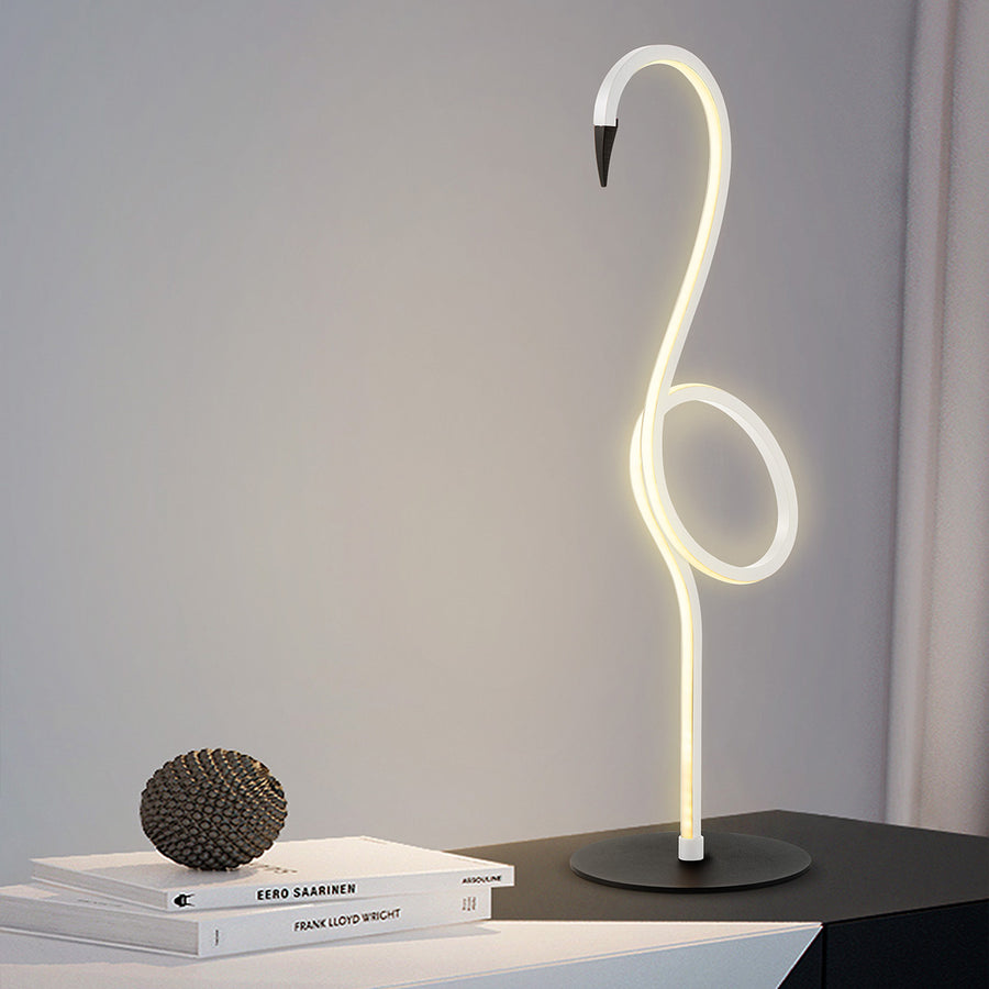 Lampe flamant lumineuse en situation sur un meuble avec livres décoratifs