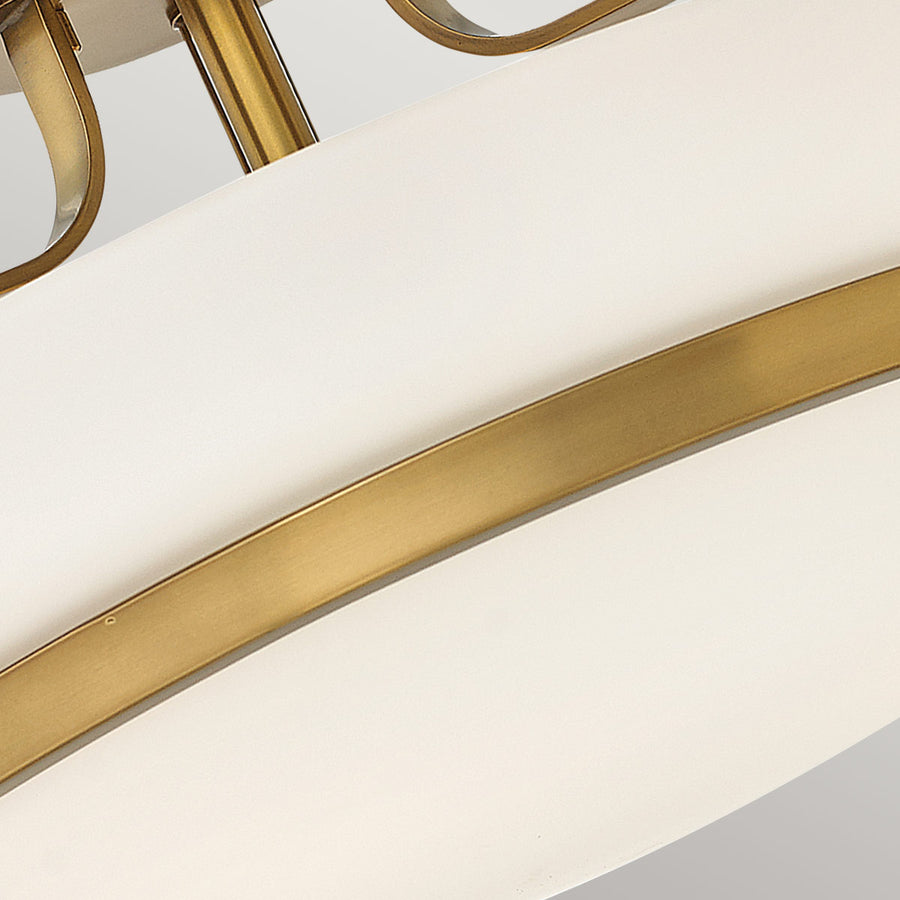 Vue rapprochée du bandeau laiton ceinturant le verre opalin blanc du diffuseur