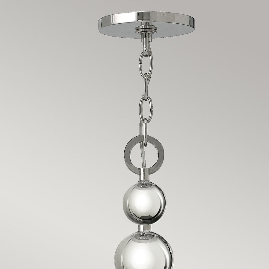 Détail de la chaîne de suspension et du cabochon rond fixé au plafond.