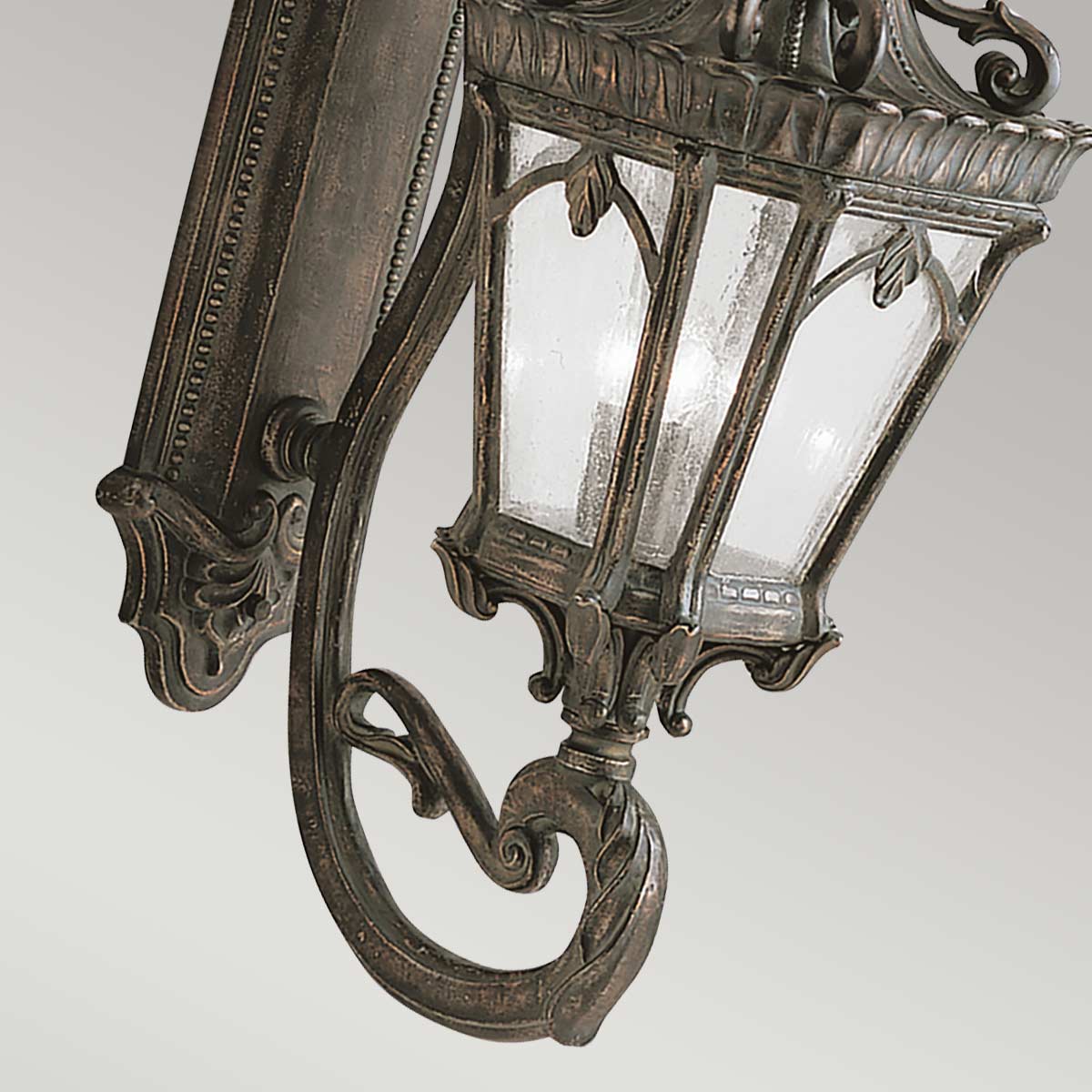 Détail du bas de lanterne avec verre martelé et volutes en bronze patiné.