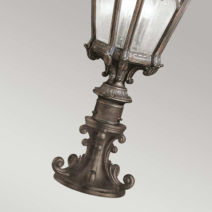 Détail du bas du lampadaire, socle ouvragé et fixation cylindrique.