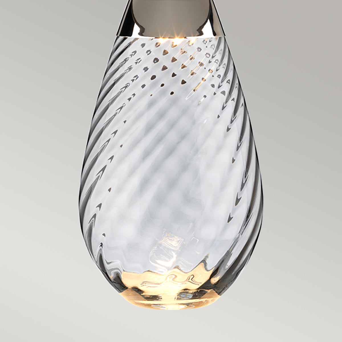 Détail de la base en verre fumé torsadé, reflets dorés et lumière chaude