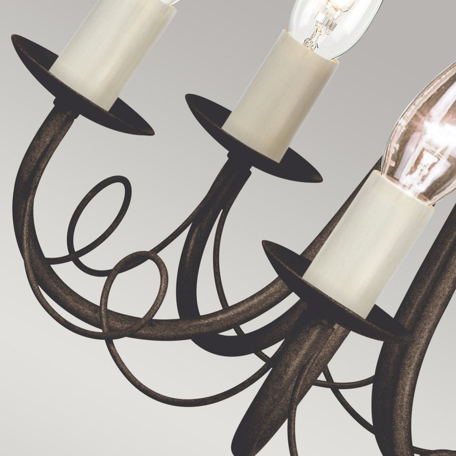 Détail des bras courbés, douilles et ampoules transparentes du luminaire noir et doré.