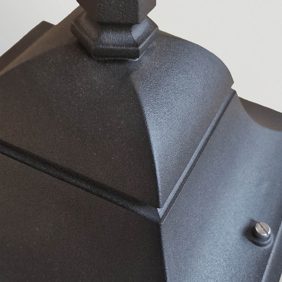 Gros plan sur la finition granuleuse noire et la visserie du chapeau