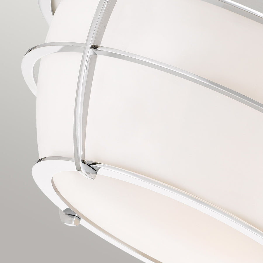 Détail de la finition chromée et croisement des tiges sur le verre blanc