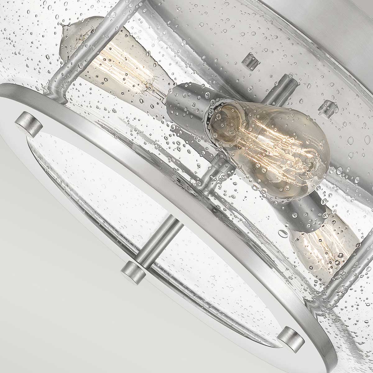 Vue rapprochée des douilles et ampoules à filament logées dans le verre moucheté