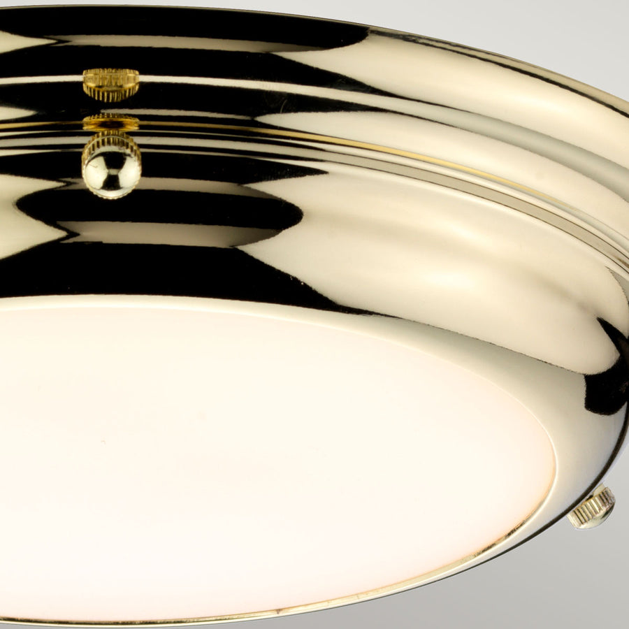 Détail du cabochon central doré reflétant la lumière sur le laiton poli