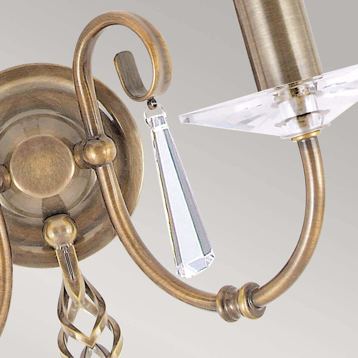 Détail d'une pampille en cristal taillé suspendue à une boucle en laiton vieilli.