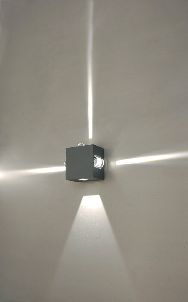 Mise en ambiance murale montrant les faisceaux lumineux croisés projetés par l'applique