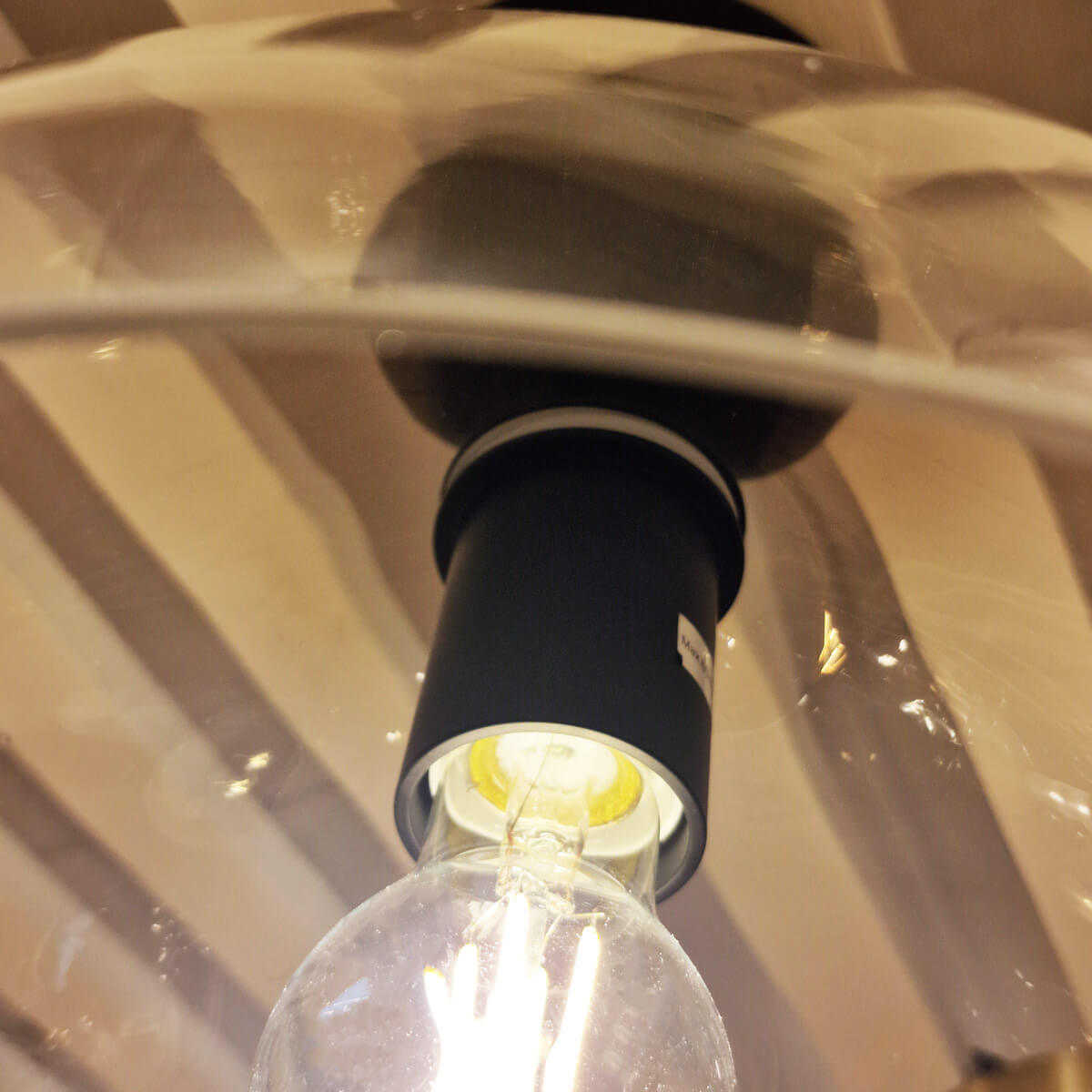 Détail de la douille noire et de l'ampoule transparente à l'intérieur du globe en verre