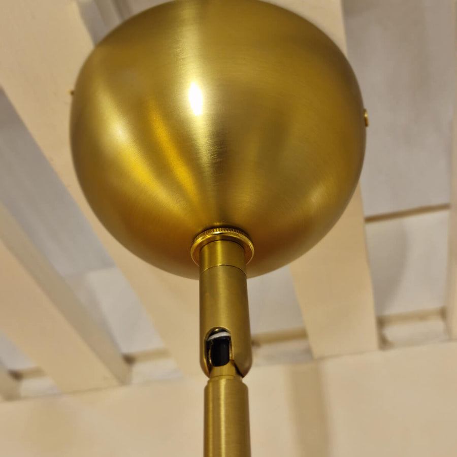 Détail de la fixation plafond en demi-sphère dorée et de sa tige
