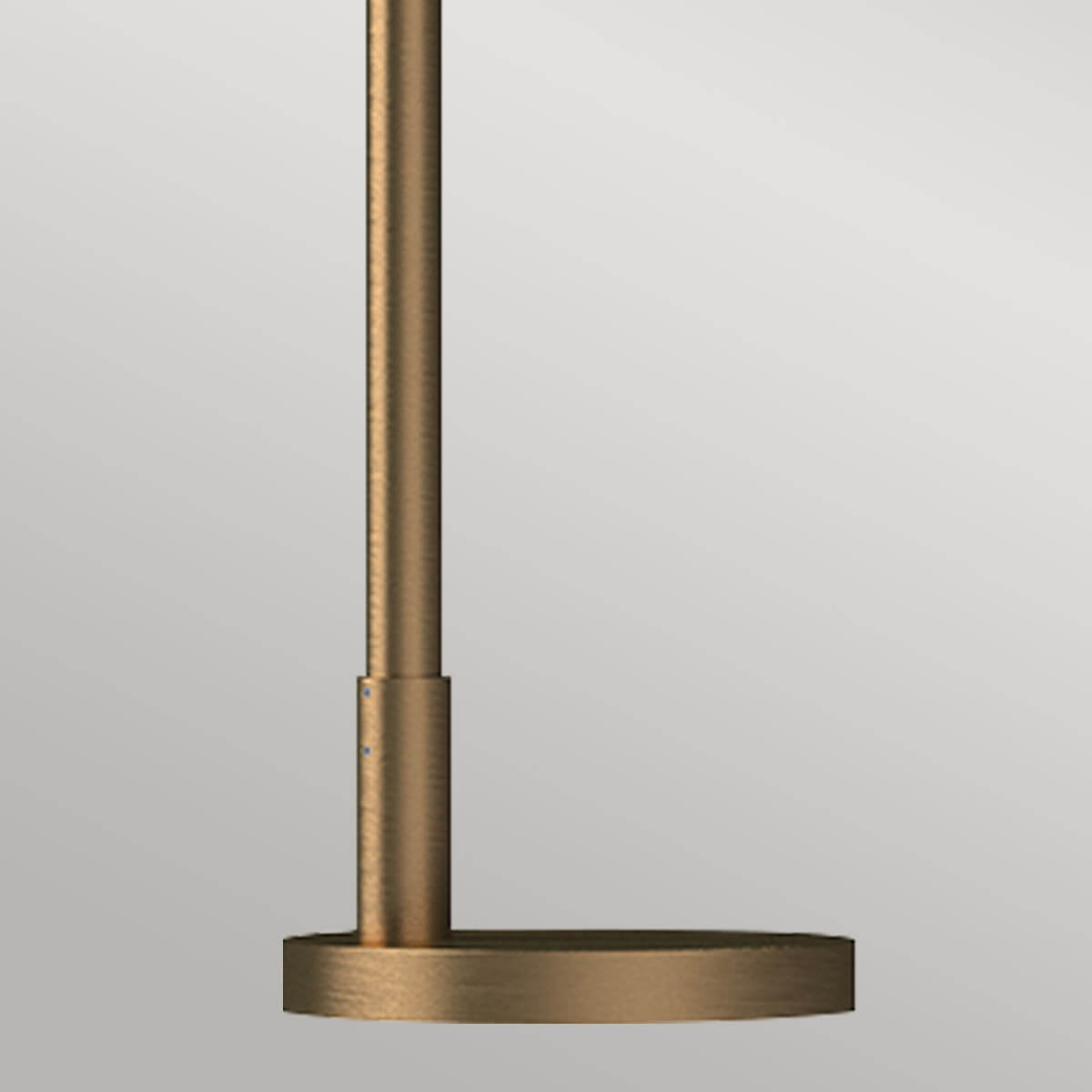Détail de la base ronde dorée et du pied cylindrique avec fixation apparente