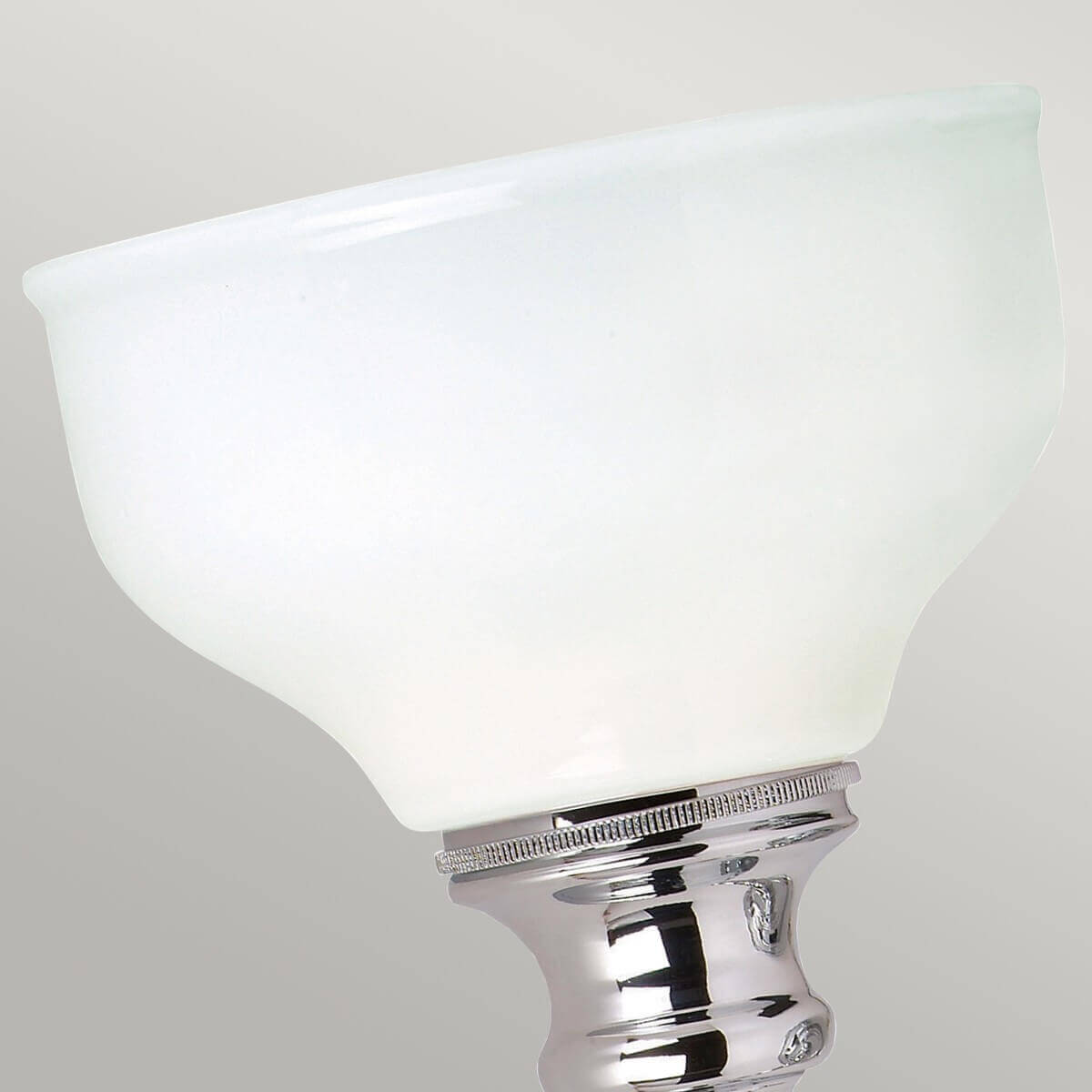 Gros plan sur la coupe en verre dépoli blanc et sa bague chromée striée