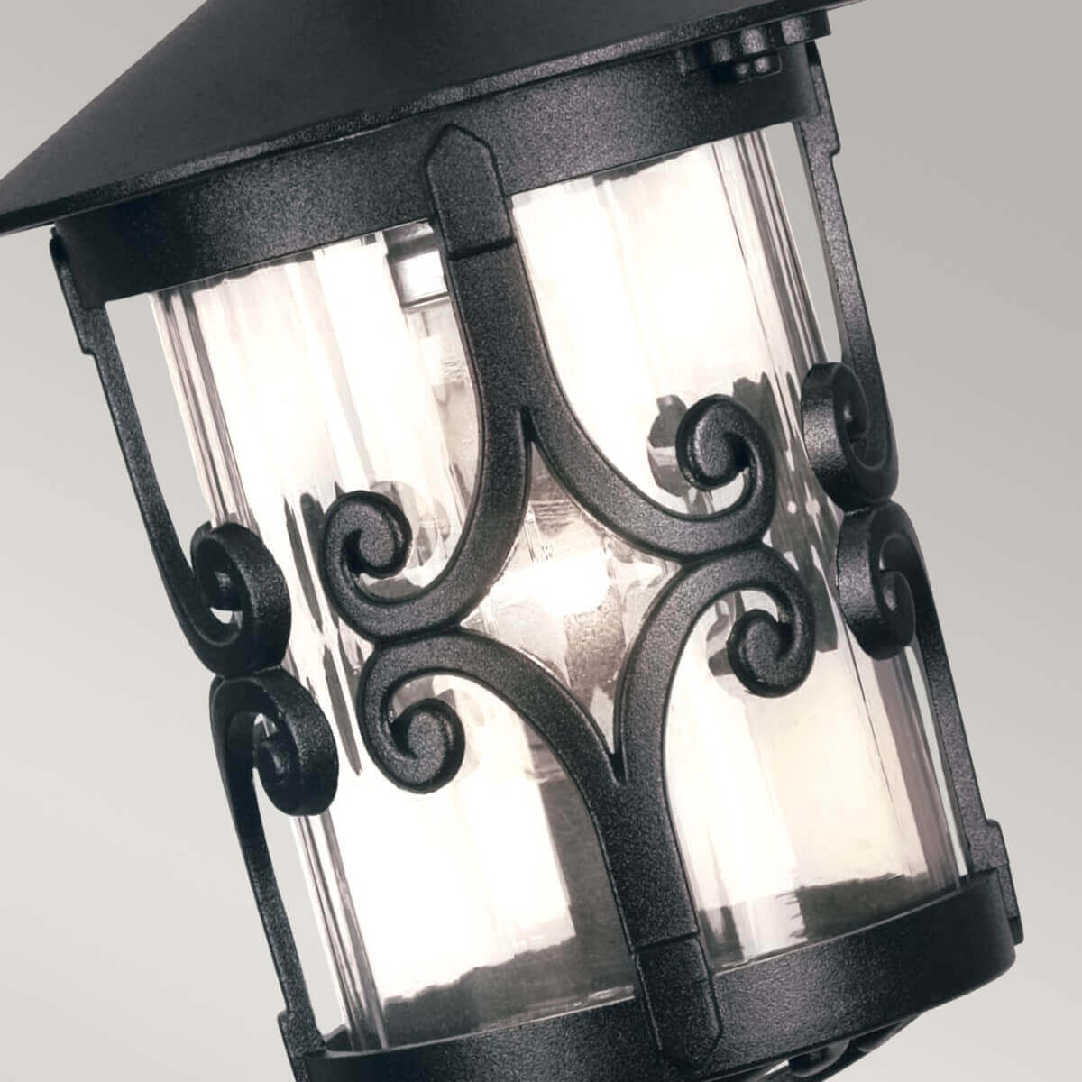 Détail des volutes en fer forgé ornant la partie supérieure du verre cylindrique