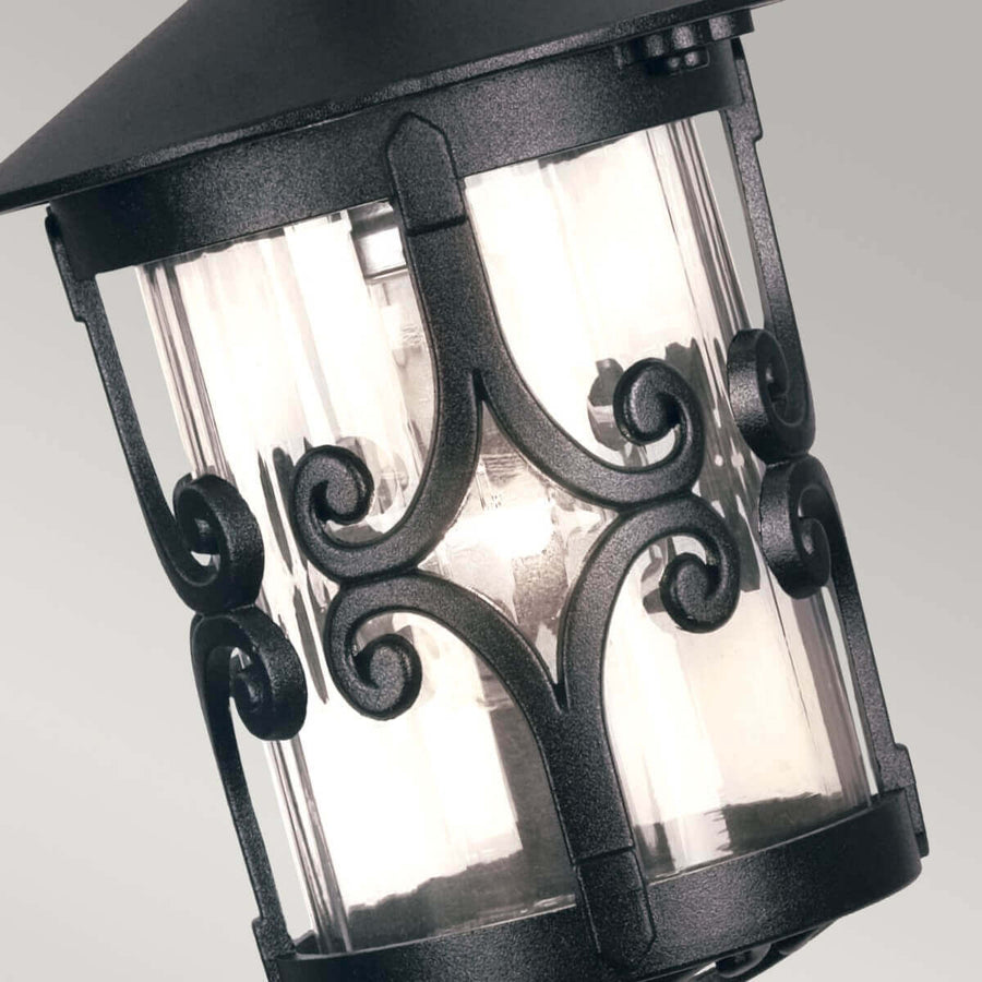 Détail des volutes en fer forgé ornant la partie supérieure du verre cylindrique