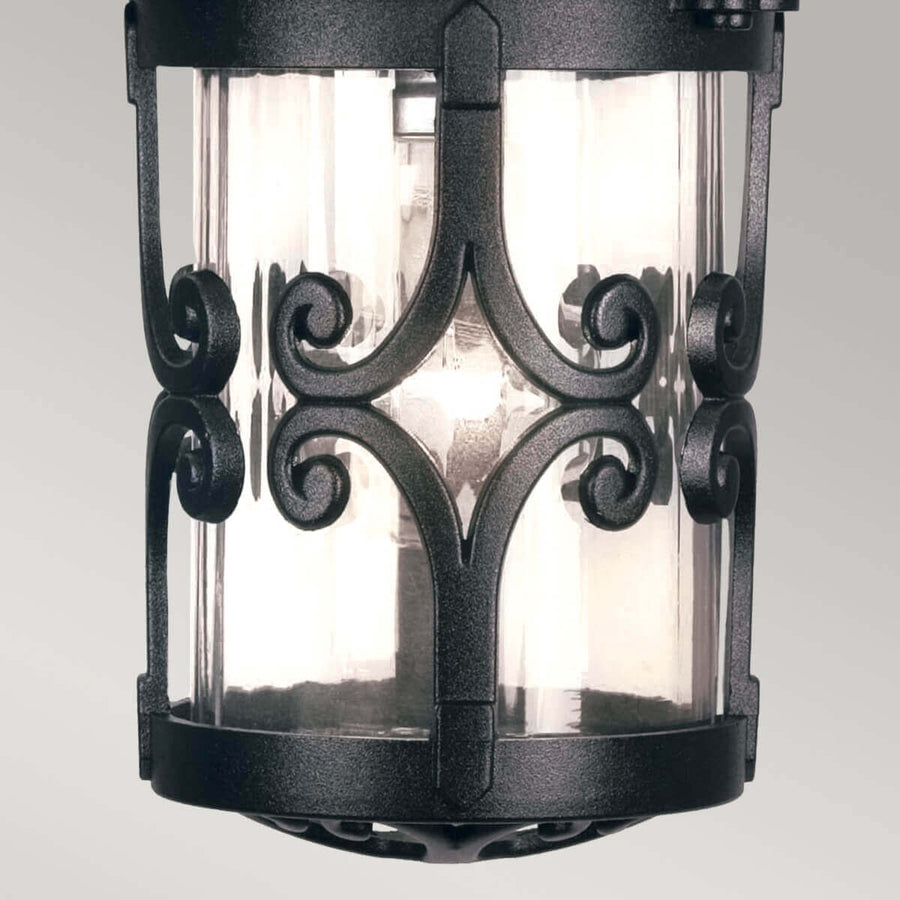Vue rapprochée du bas du luminaire montrant les arabesques et le verre strié