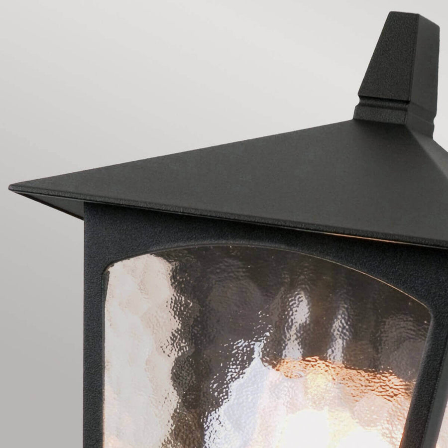 Gros plan sur le toit métallique noir et le verre texturé laissant passer la lumière