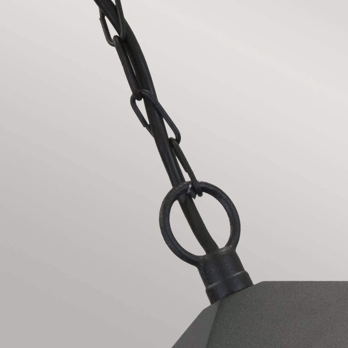 Détail de l'attache supérieure avec anneau métallique et maillons de chaîne noire