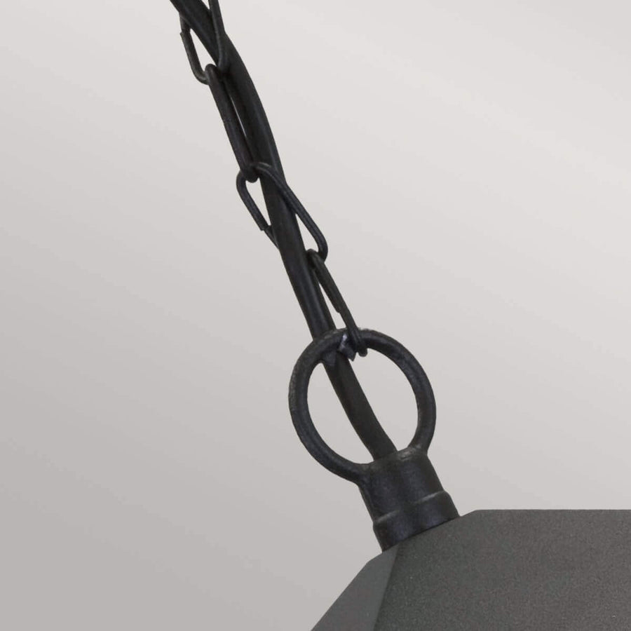 Détail de l'attache supérieure avec anneau métallique et maillons de chaîne noire