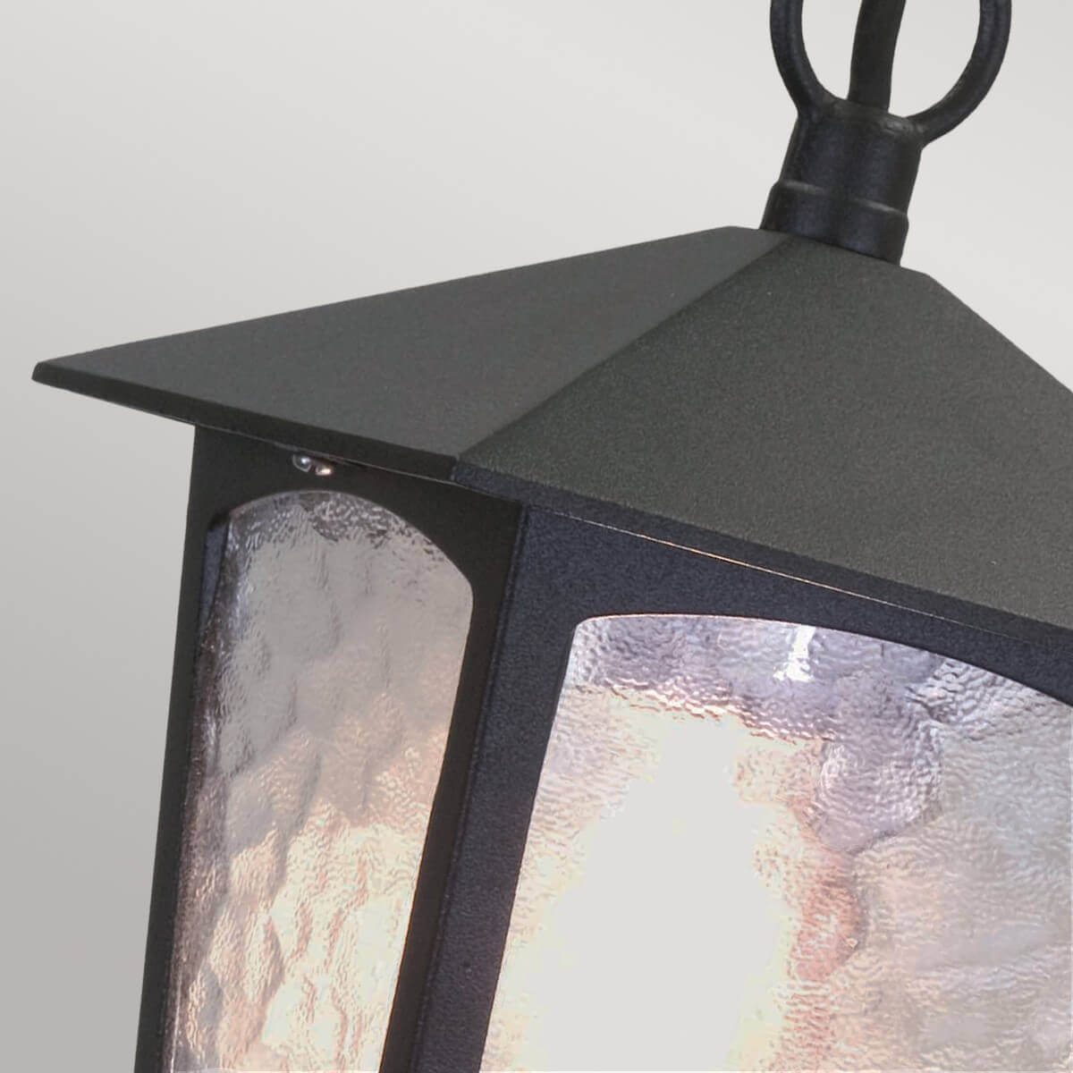 Vue rapprochée du chapeau pyramidal noir et des panneaux de verre martelé