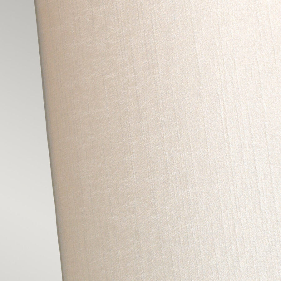 Détail rapproché de la texture tissée de l'abat-jour crème.