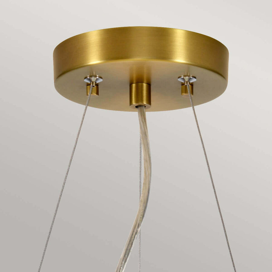 Détail de la rosace en laiton brossé avec fixations et câbles de suspension.
