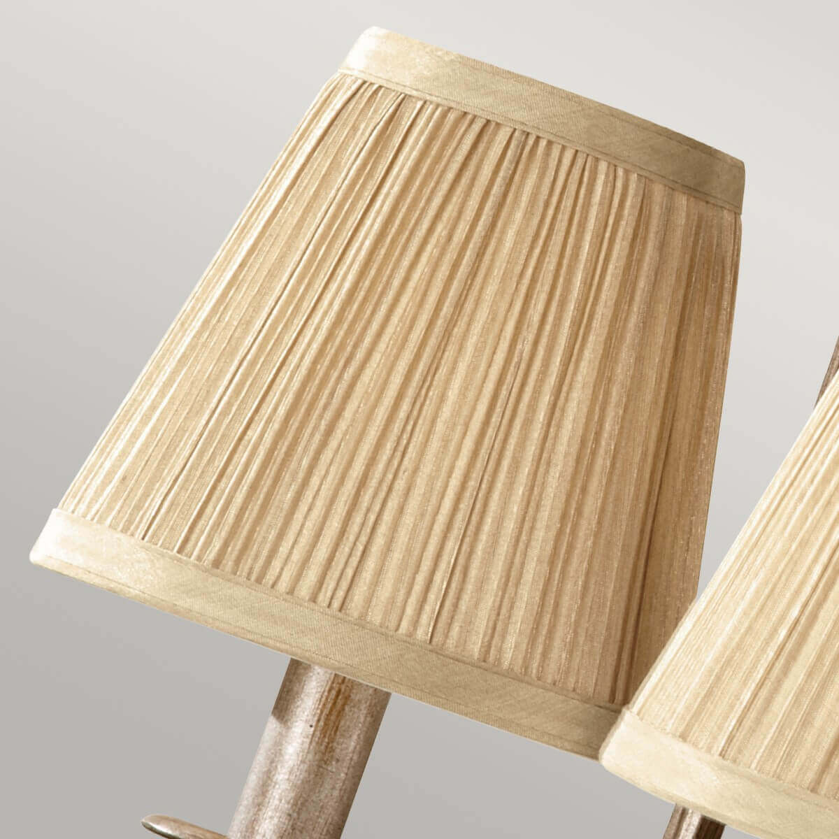 Gros plan sur un abat-jour beige plissé, bordure et doublure textile visibles