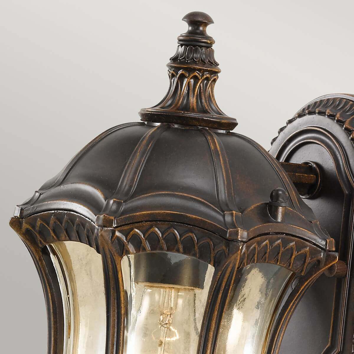 Détail du sommet mouluré et du chapeau godronné en métal patiné bronze