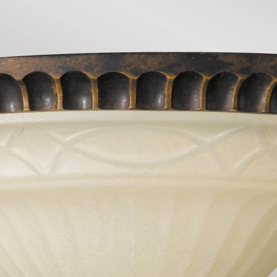 Gros plan sur la frise décorative du cerclage bronze surmontant la coupelle en verre ivoire