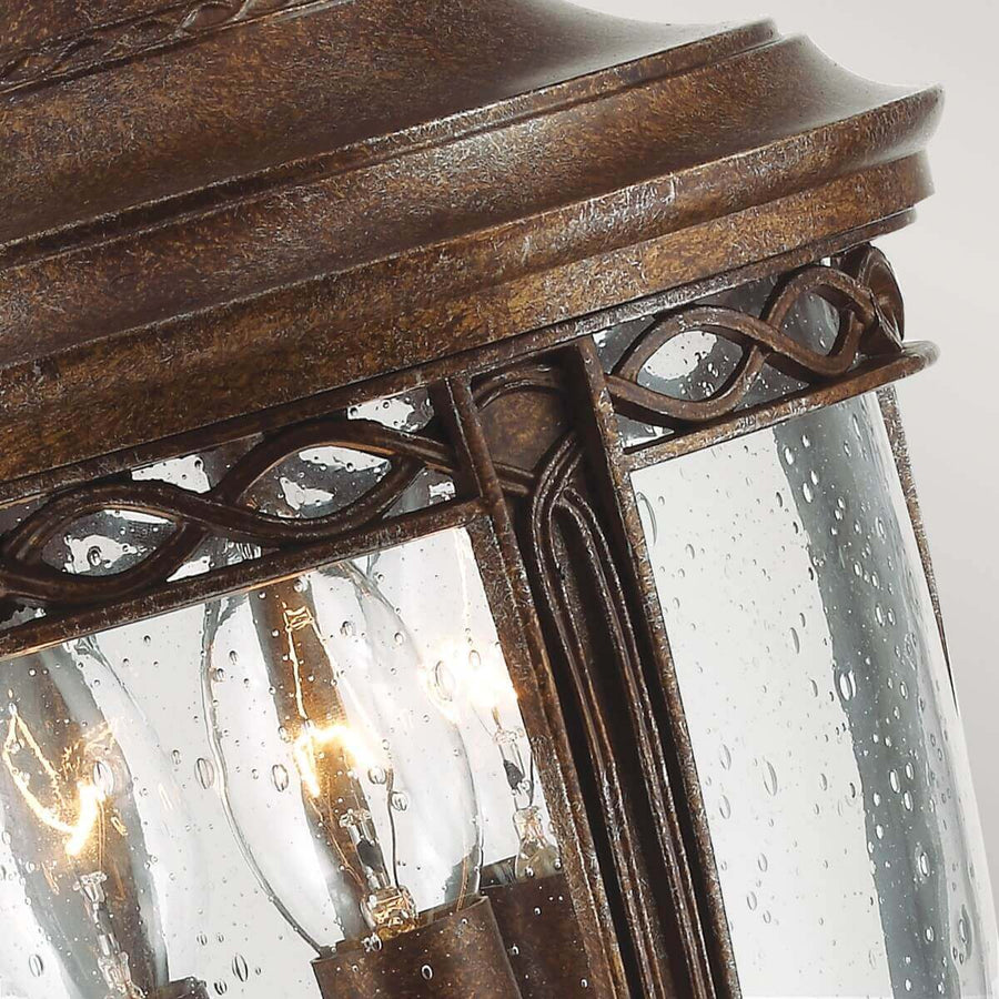 Détail du haut du luminaire avec verre moucheté et trois ampoules visibles