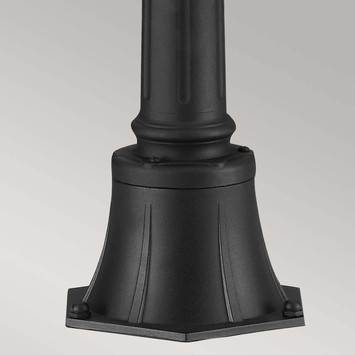Détail de la base moulurée du lampadaire avec boulons de fixation au sol