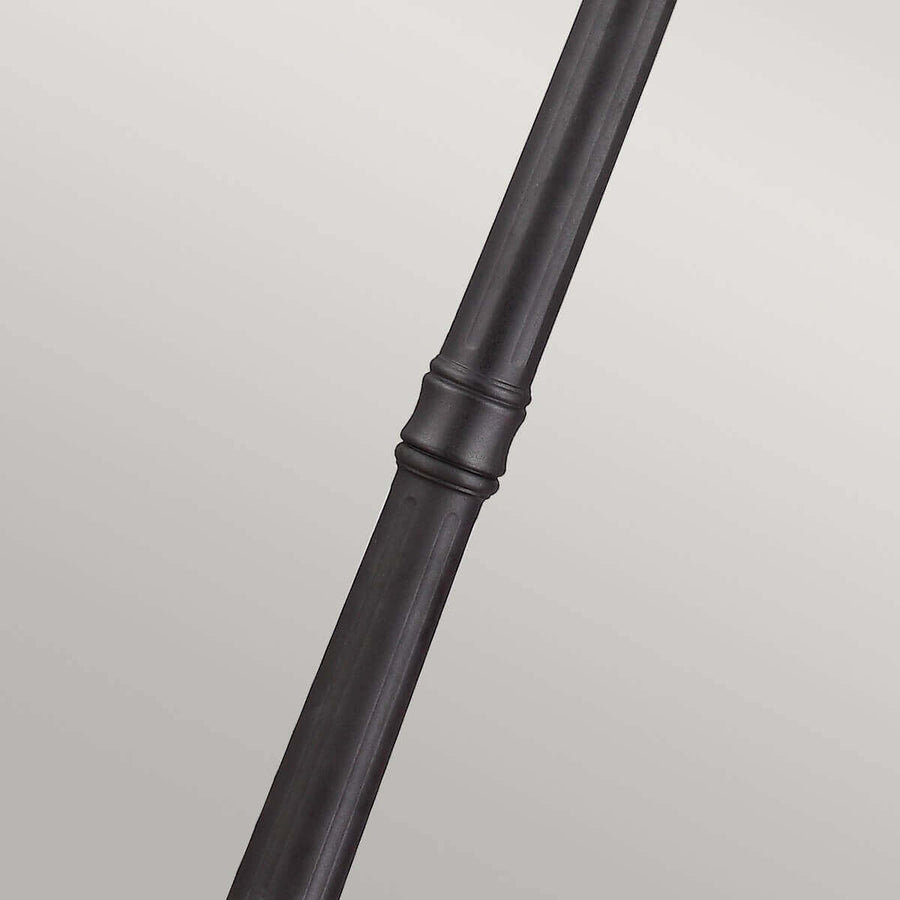 Gros plan sur le raccord mouluré du fût noir du lampadaire