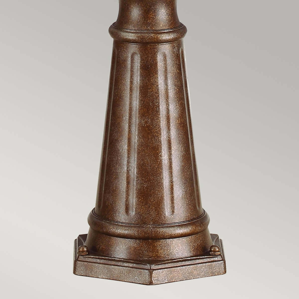 Détail de la base évasée, métal bronze martelé, socle carré à degrés et fixations.